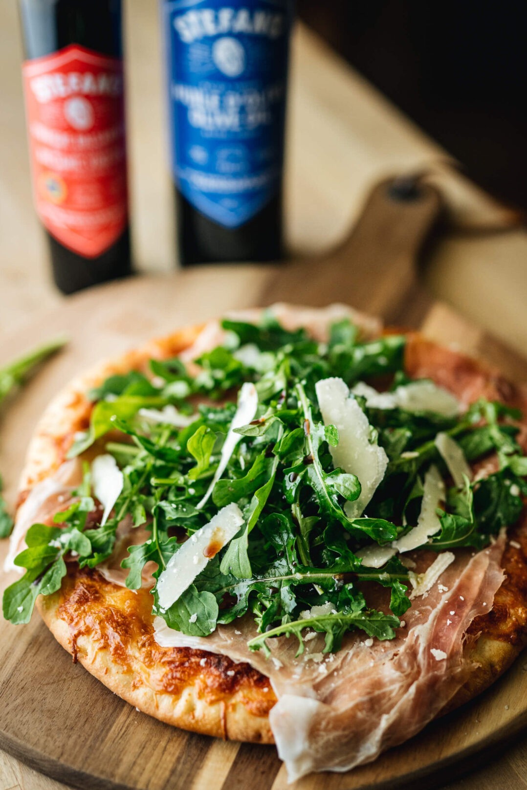 When your craving restaurant-quality pizza, but going out seems like an insurmountable task, all you have to do is make ours your own. Simply rethink what you know of tomato and cheese pizza: not as a dish in itself, but as a canvas and pimp it to your liking. Here, we simply add prosciutto and some arugula salad. Your turn to play!