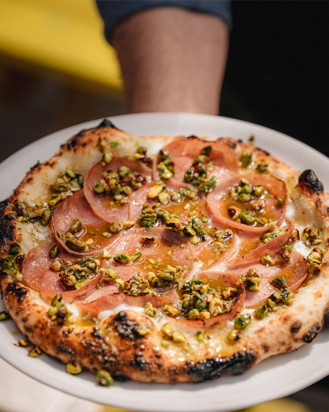 Homemade pizza with mortadella and pistachio pesto