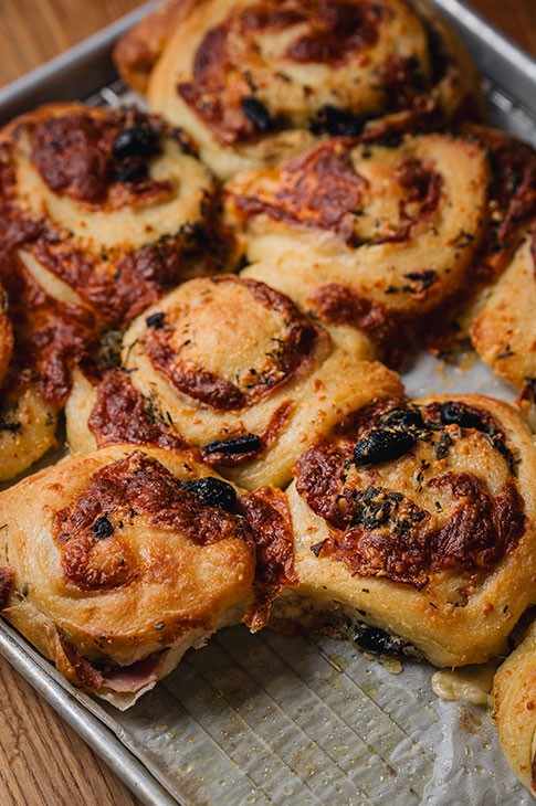 The simple mention of “ham and cheese” is enough to get everyone excited. This recipe puts a nice Italian spin on the cult duo with the addition of olives, Parmesan, prosciutto cotto, and a nice handful of fresh herbs. These gourmet pinwheels are absolutely delicious and truly fantastic on any occasion.