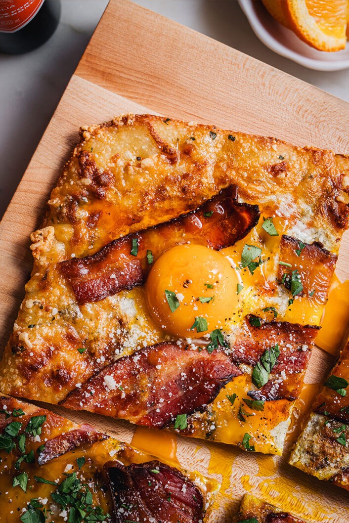 Deux mots, une idée de génie : pizza déjeuner. Pas besoin de préparer tout plein de plats séparés, ici, tous les éléments essentiels d’un brunch réussi (coucou cocos et bacon!) se retrouvent sur une seule et même belle pâte dorée.