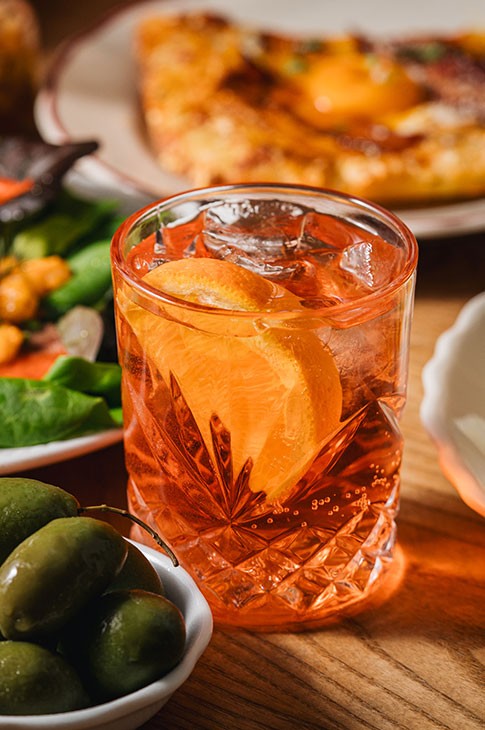 This sunset-colored cocktail has become the emblem of the Italian aperitivo and a true international star. A simple mix of sparkling wine, with sparkling water or seltzer water and bitter liqueur (Aperol, Campari red, or Amermelade), not to mention ice cubes and an orange slice.