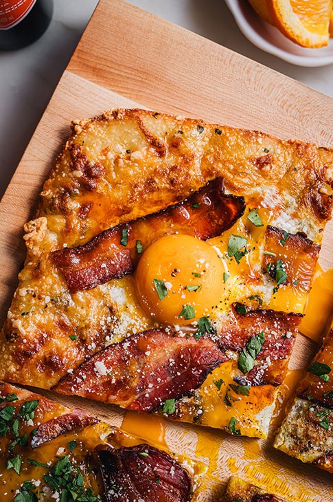 Two words, one genius idea: breakfast pizza. This recipe would be perfect for Mother’s Day brunch (or any brunch, lunch or dinner for that matter). It’s beautiful, delicious, AND easy to make. No need to cook a bunch of separate dishes—this breakfast pizza recipe brings together all the ingredients of a successful brunch (hello, eggs and bacon) on one crusty, golden dough.