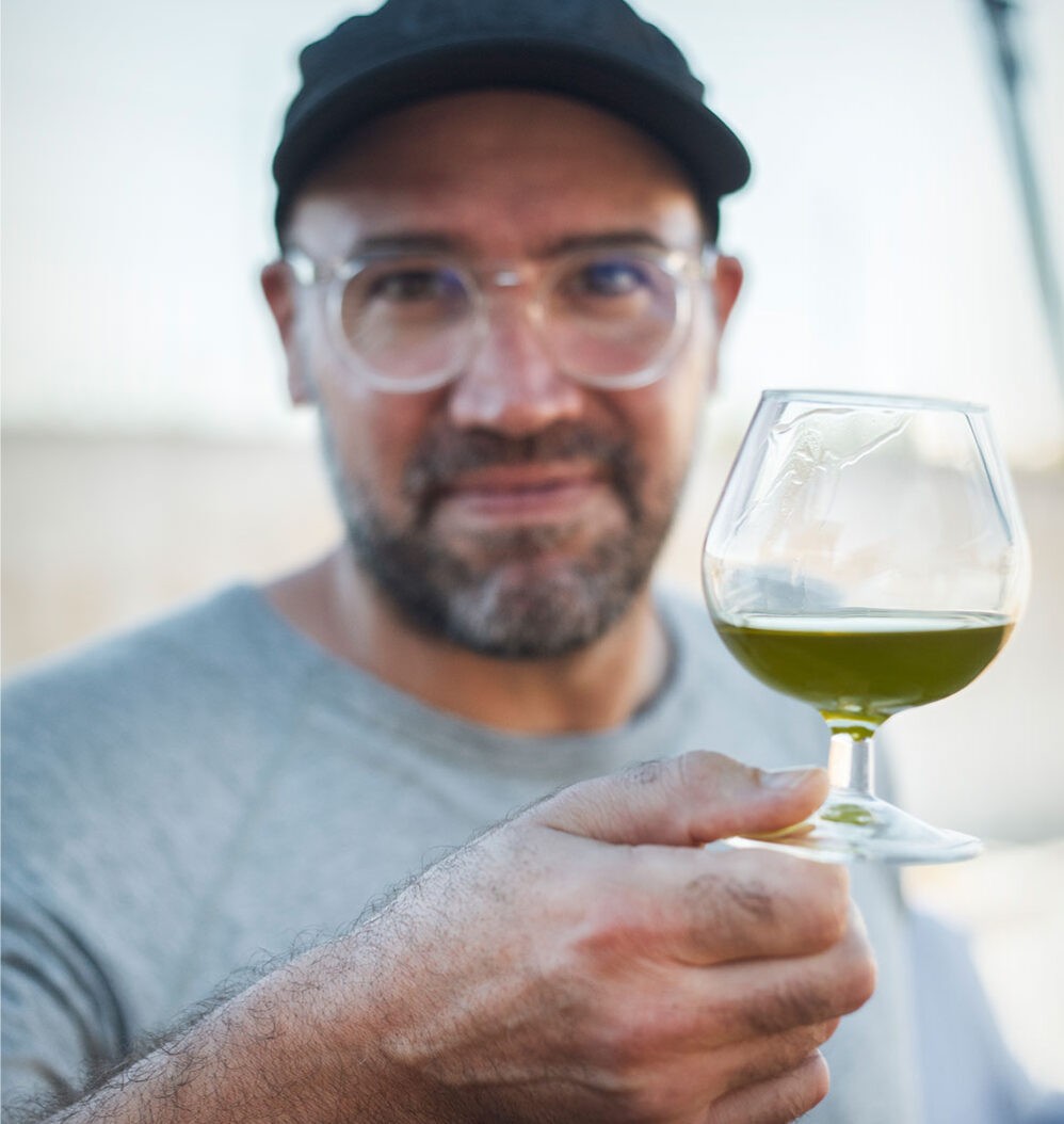 Stefano Faita qui tient un verre d'huile d'olive